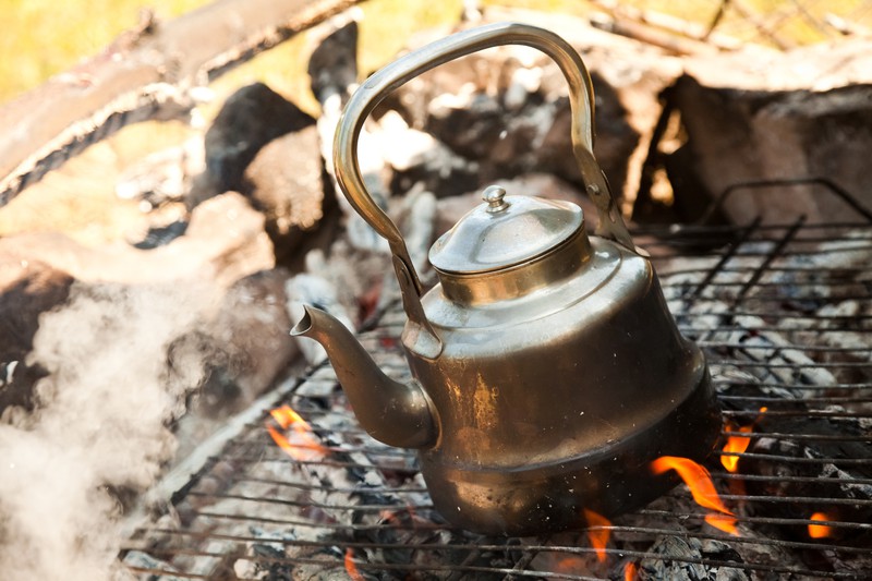 Ein alter Teekessel über einem Feuer