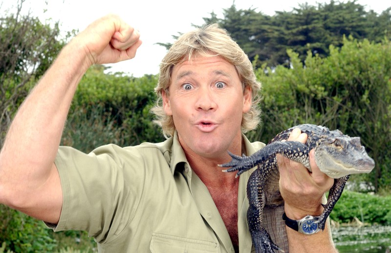 Steve Irwin ist auf dem Bild zu sehen mit einem Reptil und es geht um seinen Sohn, der ebenfalls ein Krokodil füttert-