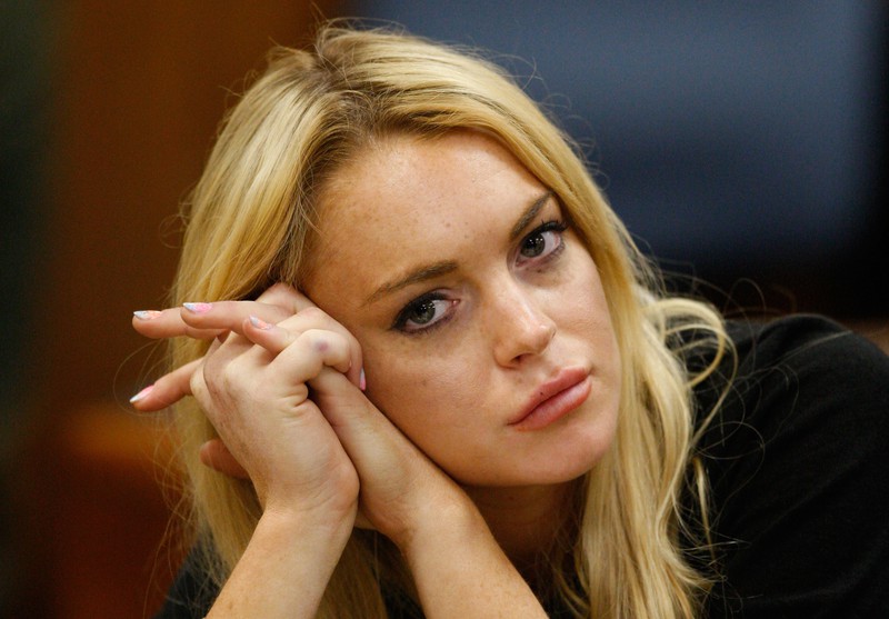 Man sieht Lindsay Lohan und dass sie traurig aussieht, weil sie unter Drogen- und Alkoholeinfluss stand und eine Haftstrafe antreten musste