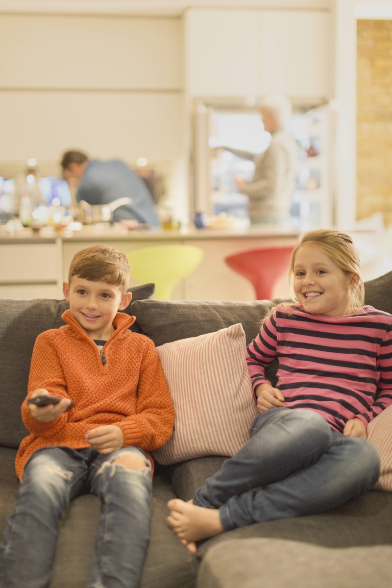 Man sieht Kinder, die im Fernseher gerade die Abenteuer ihrer Disney-Figuren verfolgen