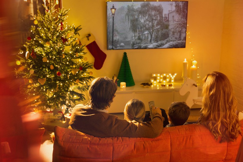 Man erkennt eine Familie, die sich auf Weihnachten einstimmen will und daher Weihnachtsfilme schaut
