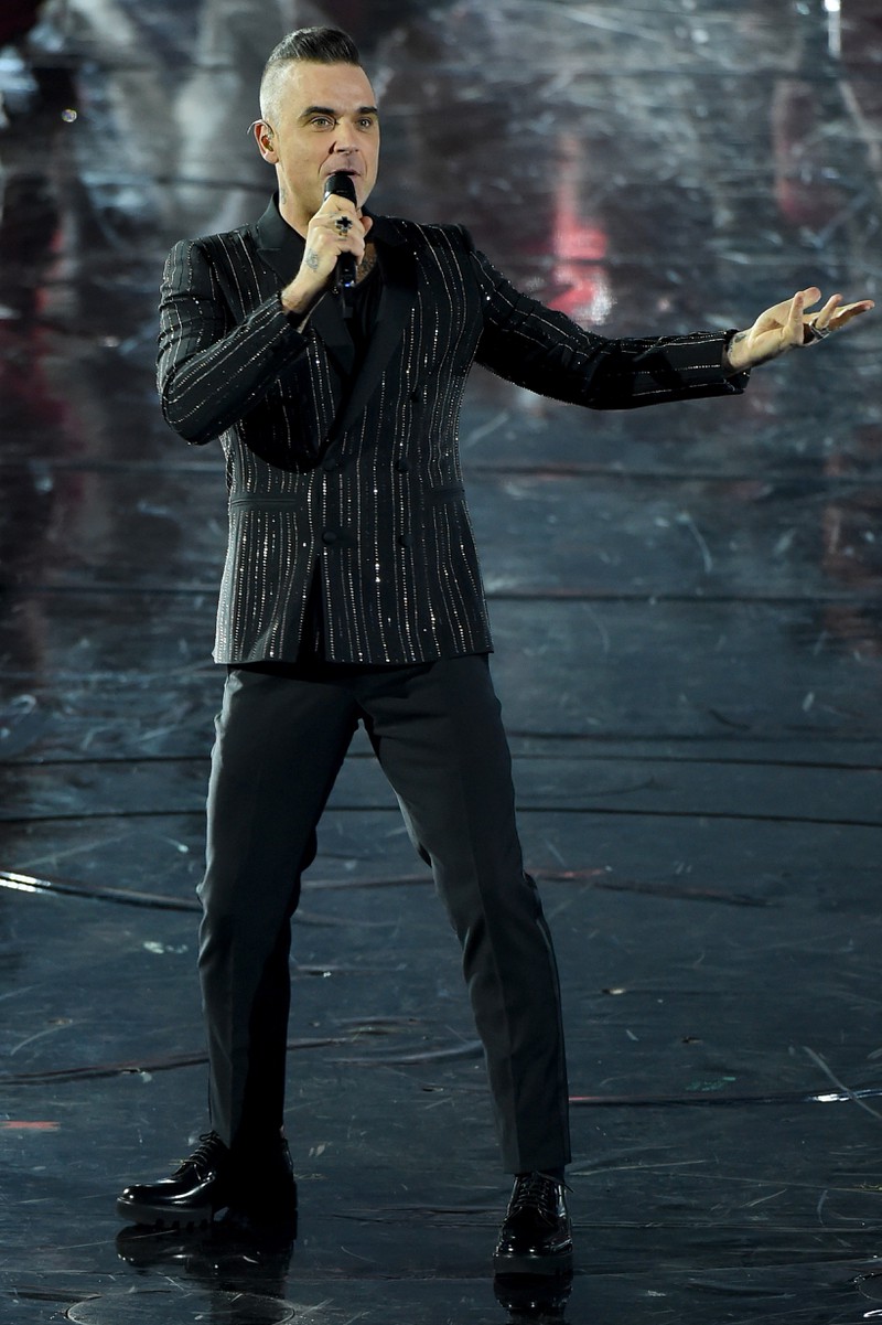 Robbie Williams 2019 auf einer Bühne im Anzug