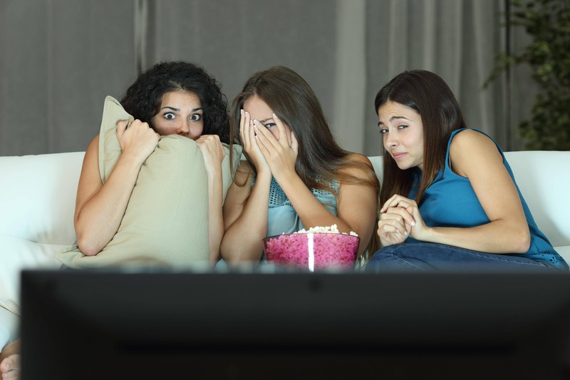 Drei Frauen schauen eine spannende spanische Serie an.