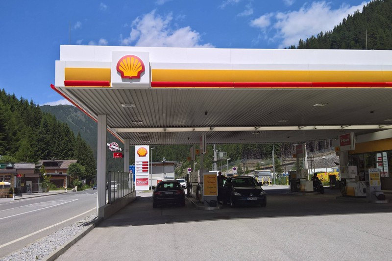 Man sieht eine Tankstelle, die mit dem Shell Logo gespickt ist